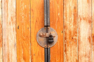 Old rusty with padlock on a wooden door.
