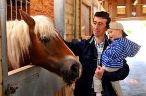 Father and son with horse at the stables